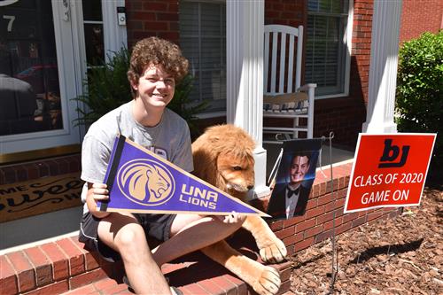 Student holding UNA Lions pennant 