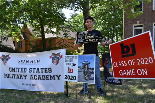 student with WestPoint Military Academy banner in yard 