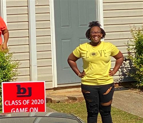 Student standing in front yard with Class of 2020 Game On sign 