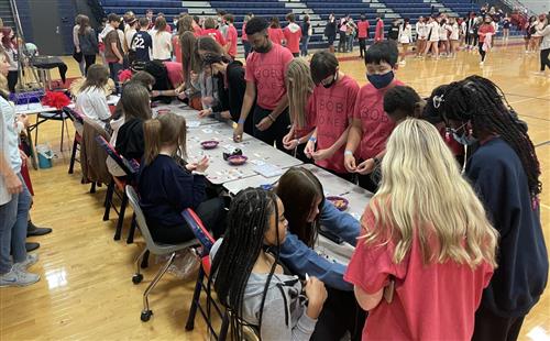 students around a table asking older students questions about course options