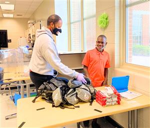 Student and teacher stuffing packs with COVID-19 sanitizer supplies 