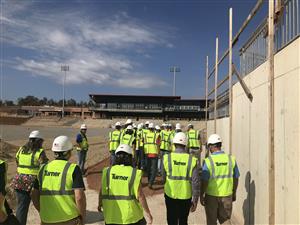 Students walking by entrance wall of stadium 