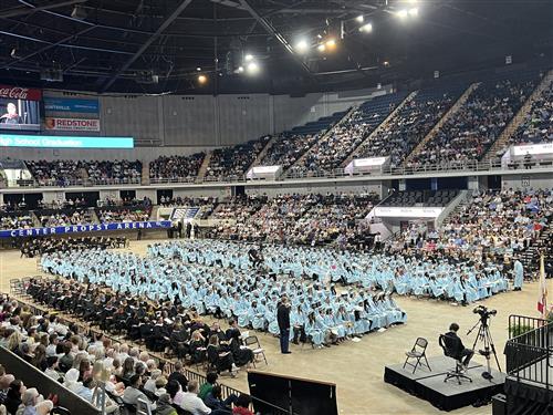 view from balcony of James Clemens graduates seated on arena floor