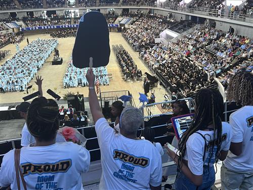 family from upper deck waving down on their graduate from James Clemens High School