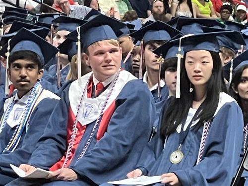 three top Bob Jones graduates seated in the front in their caps and gowns