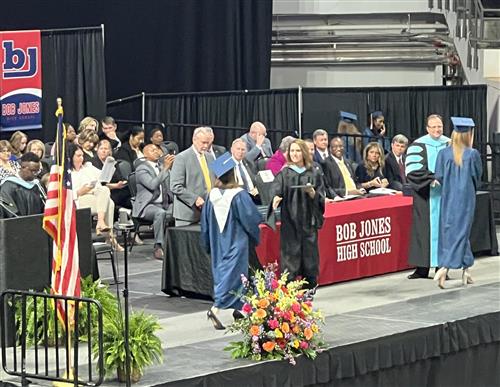 Bob Jones principal handing out diplomas on stage