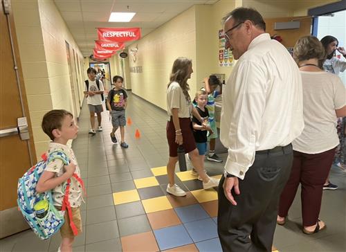 Dr. Nichols in hallway greeting student