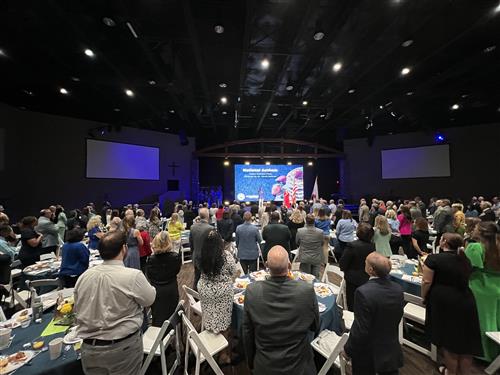 wide angle photo of crowd seated in the cavernous reception room