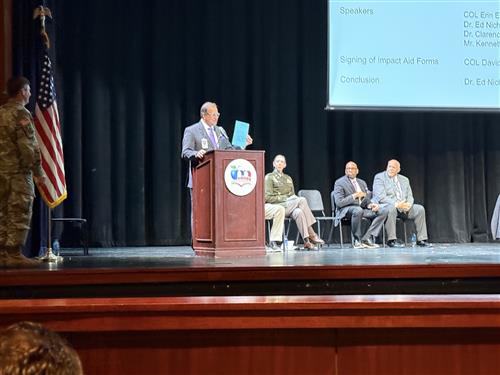 Dr. Nichols holds up paper form of Impact Aid