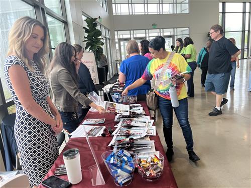 vendors man swag tables outside the auditorium