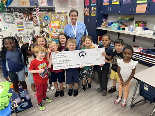 PreK teacher standing with students surrounding her