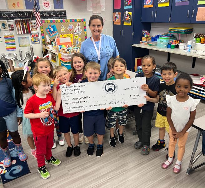  teacher with students surrounding her in smiles