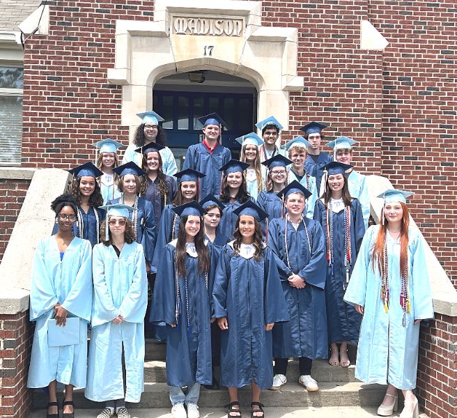  students in Bob Jones and James Clemens graduation gowns on steps of Madison Elementary 