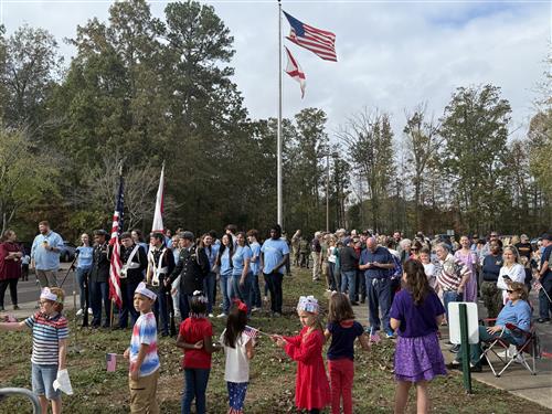 far away pic of flag ceremony outside of school