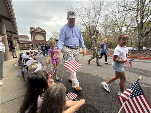 veteran high fiving students along vet parade route