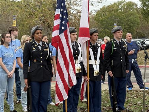 school honor guard outside school during flag ceremony