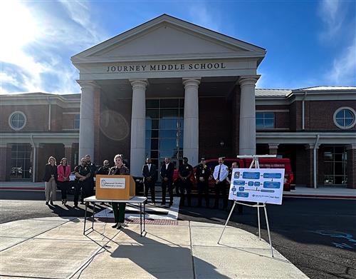 officials in foreground with Journey Middle main entrance  behind them