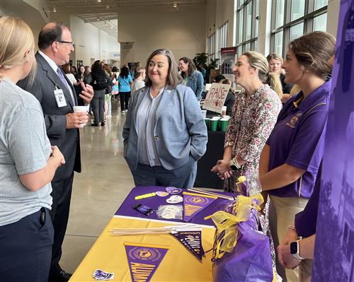 Vendors talking to school leaders at swag table