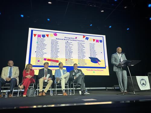 Assistant superintendent Eric Terrell on stage with board