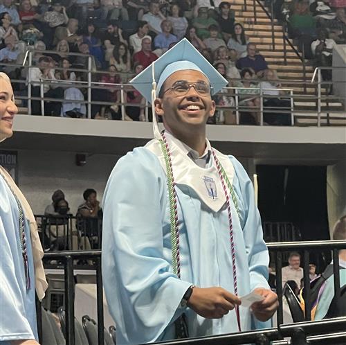 James Clemens grad smiling up at family from stage to getting his diploma