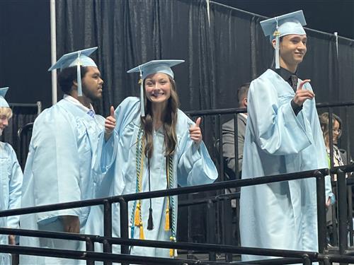 james clemens graduate on stage giving thumbs up