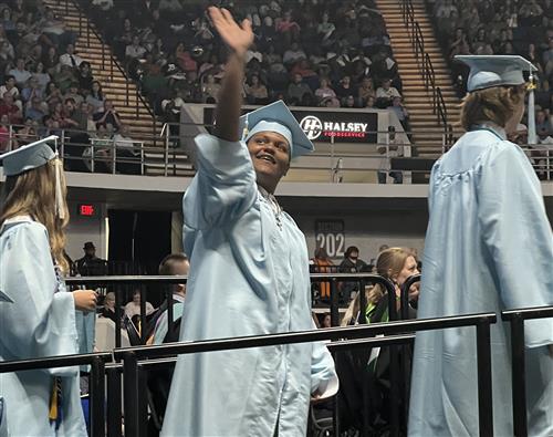 James clemens graduate waving to family in balcony from ramp to stage
