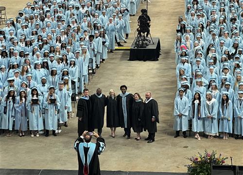 James Clemens principals and assistant principals in front of graduates sitting behind them