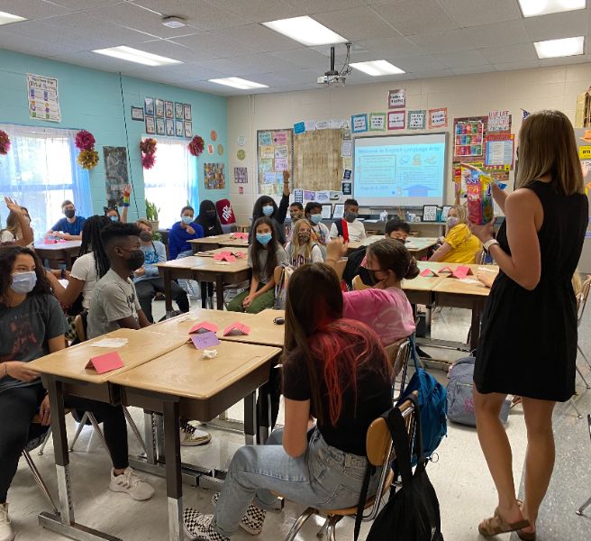  teacher in front of class teaching