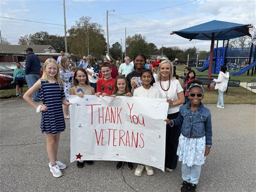 students holding a thank you veterans sign