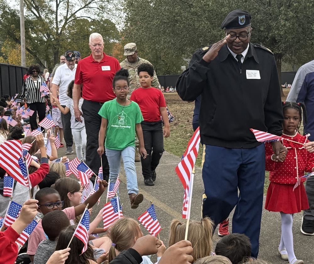  Military dad in uniform saluting row of kids holding flags along a school track