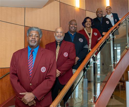 A group of people are posing for a photo on a staircase.