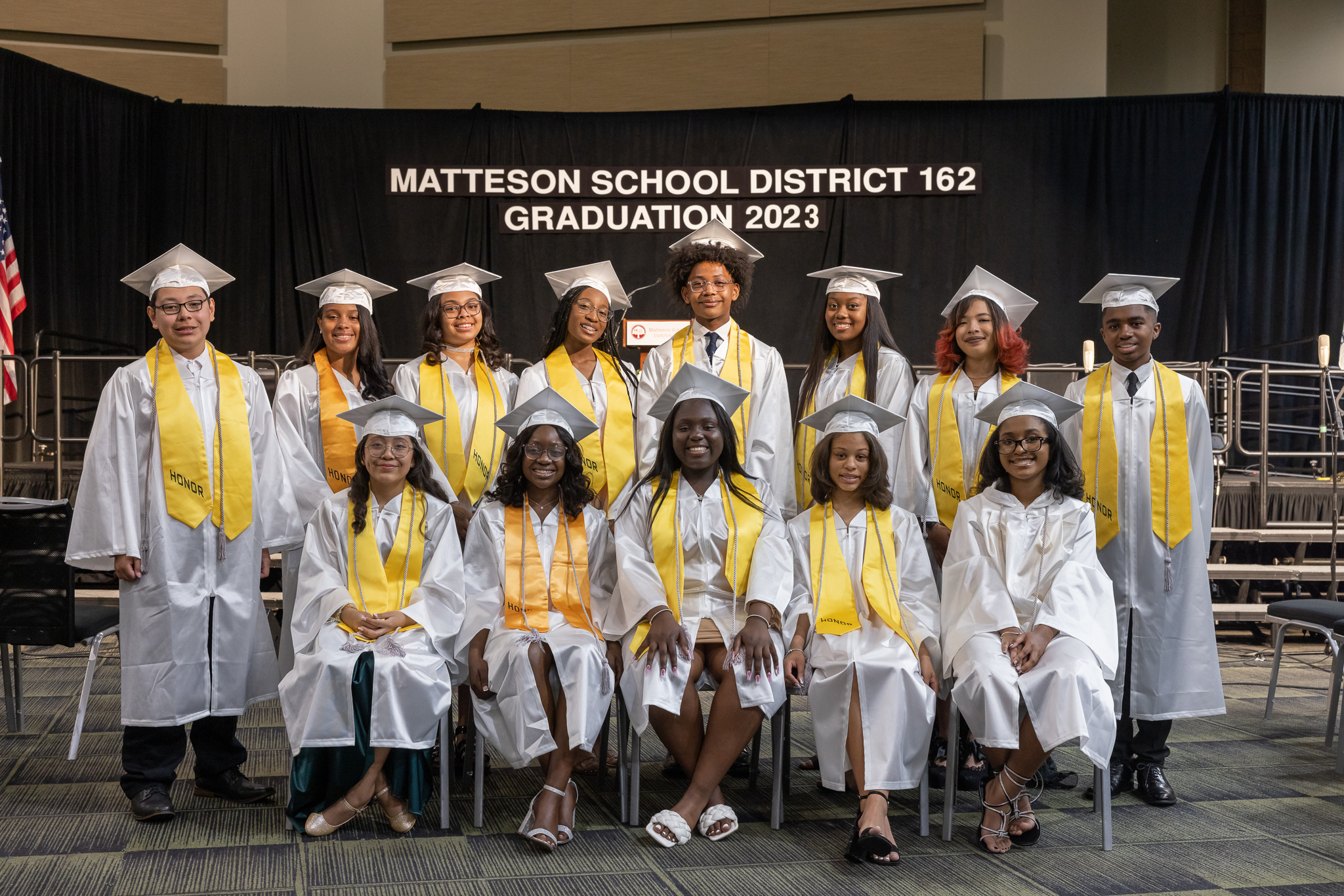 A group of students are posing for a photo in their graduation caps and gowns.