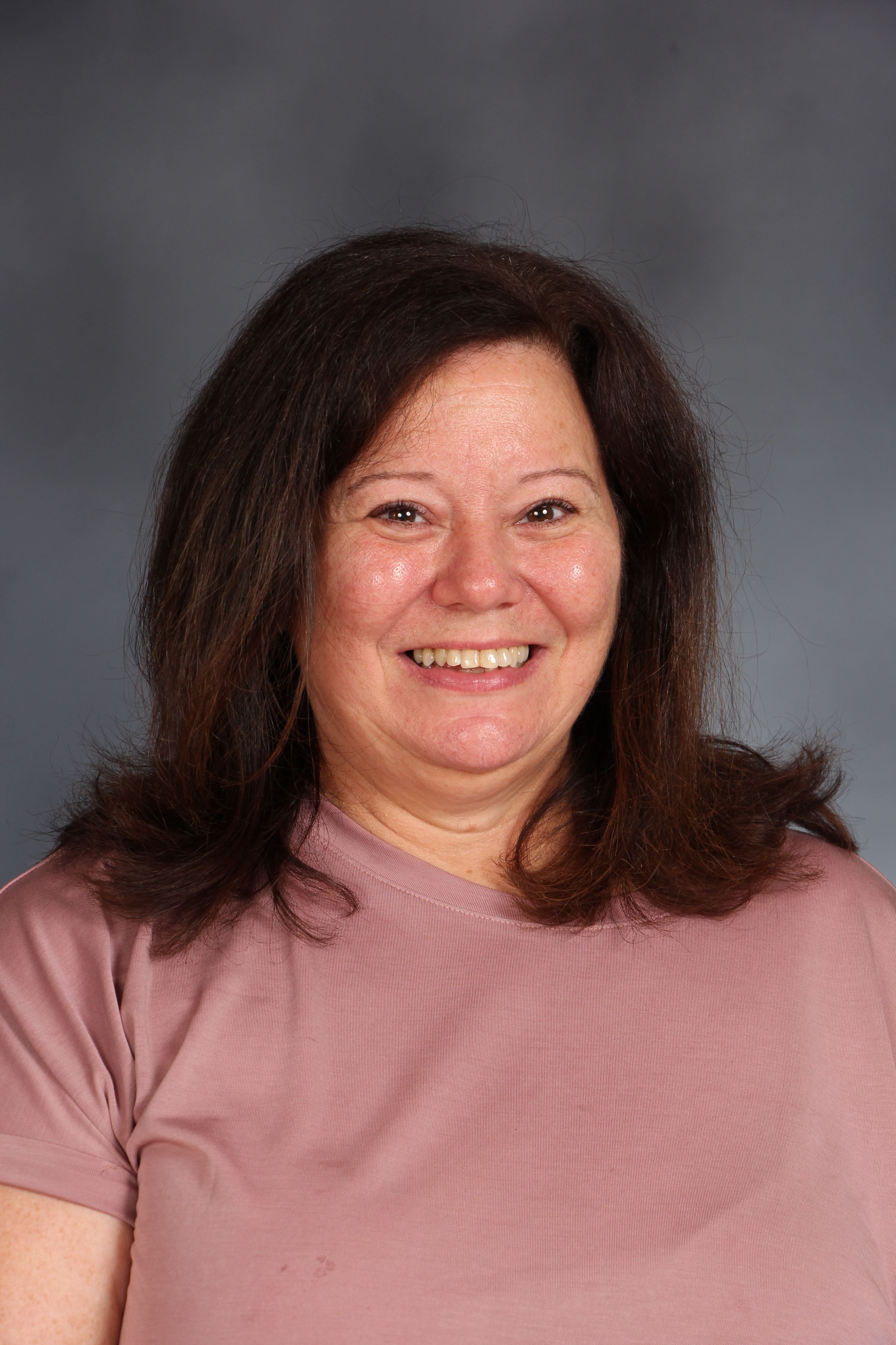 A headshot of a person with long brown hair.