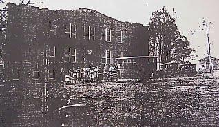  1924 Photograph of school "trucks" and bus students. The small building at the right of the main building was the band room.