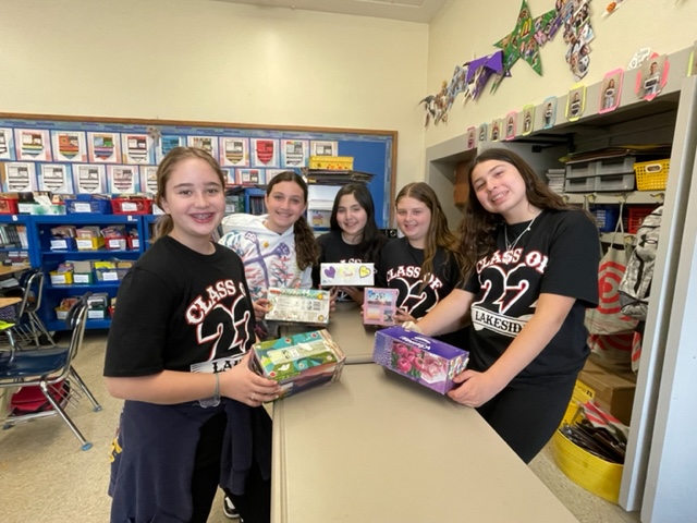 students holding colorful boxes