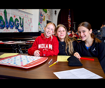 Three young people playing Scrabble