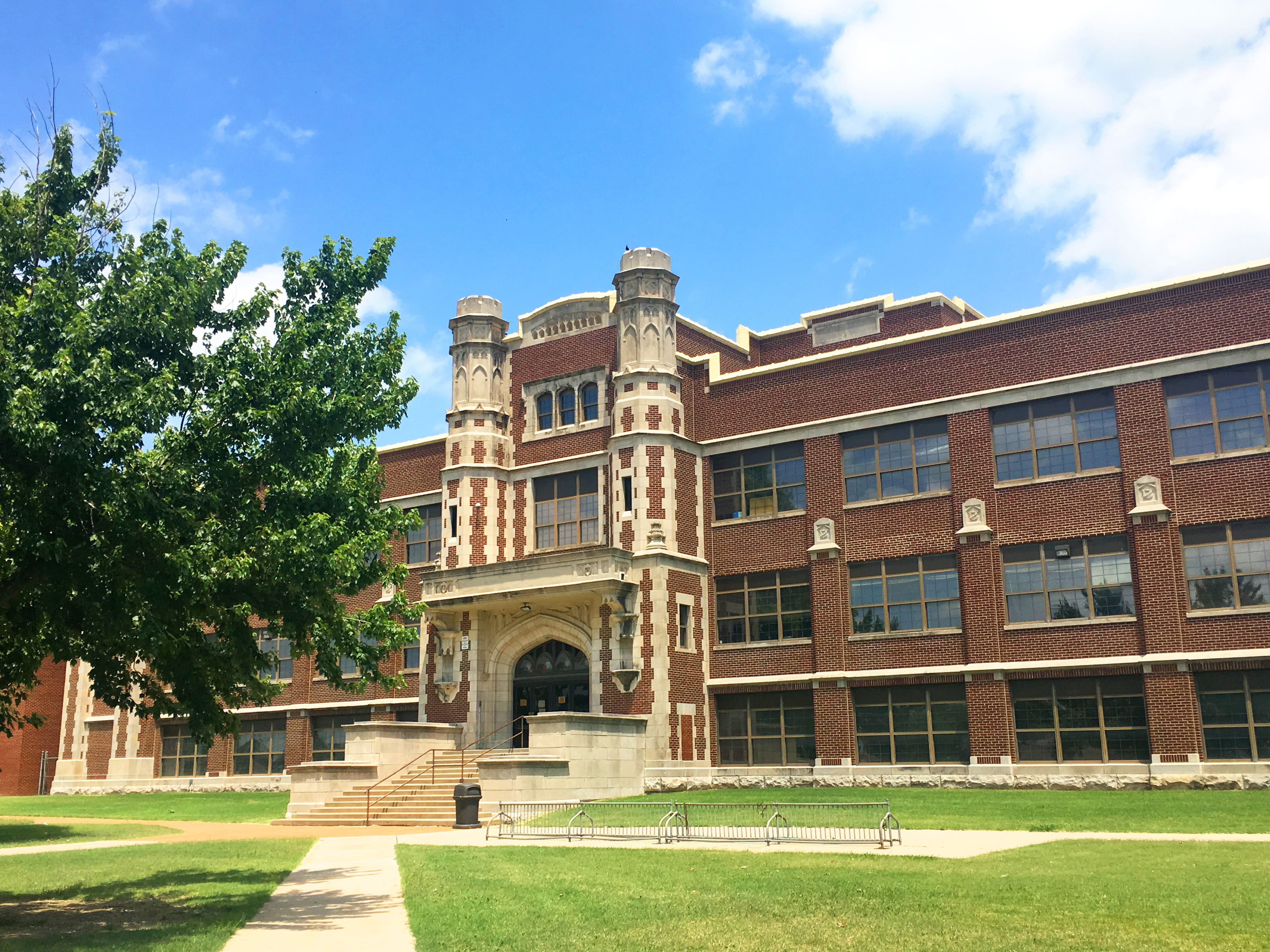 The front of Mertz Middle School, a three story brick building, on a sunny day.