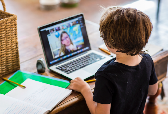 Young boy using a laptop to video chat.