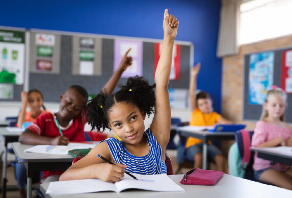 Young girl with her hand raised.