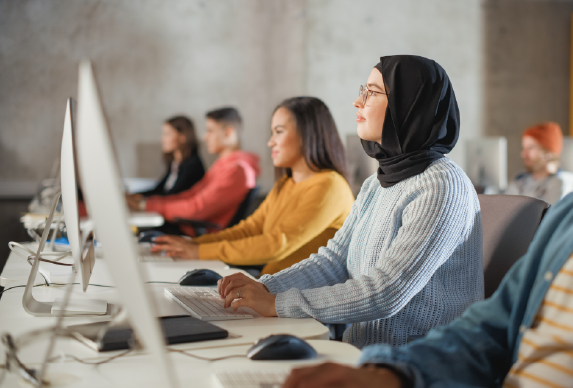 Girl wearing hijab using a computer.