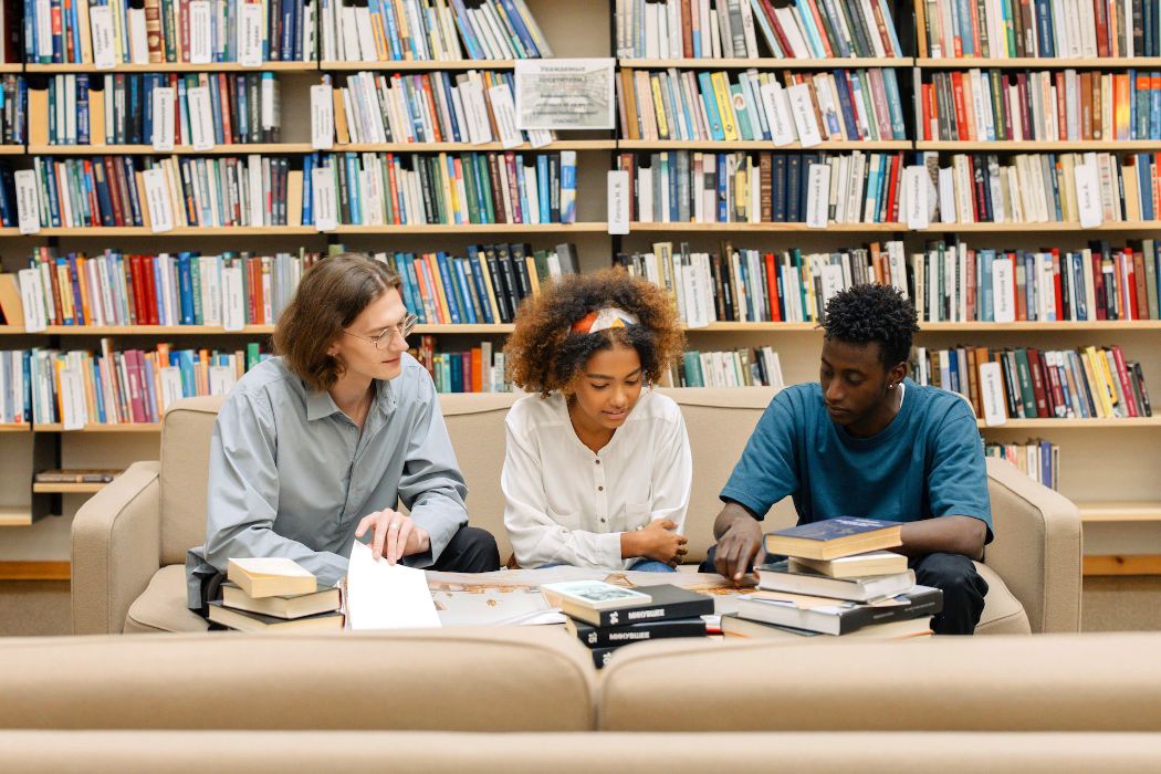 A group of people are looking at books in a library.