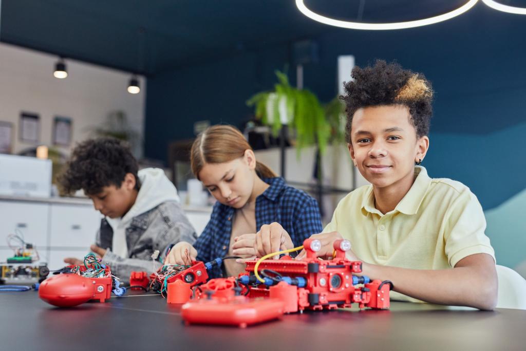 three students working on robotics parts