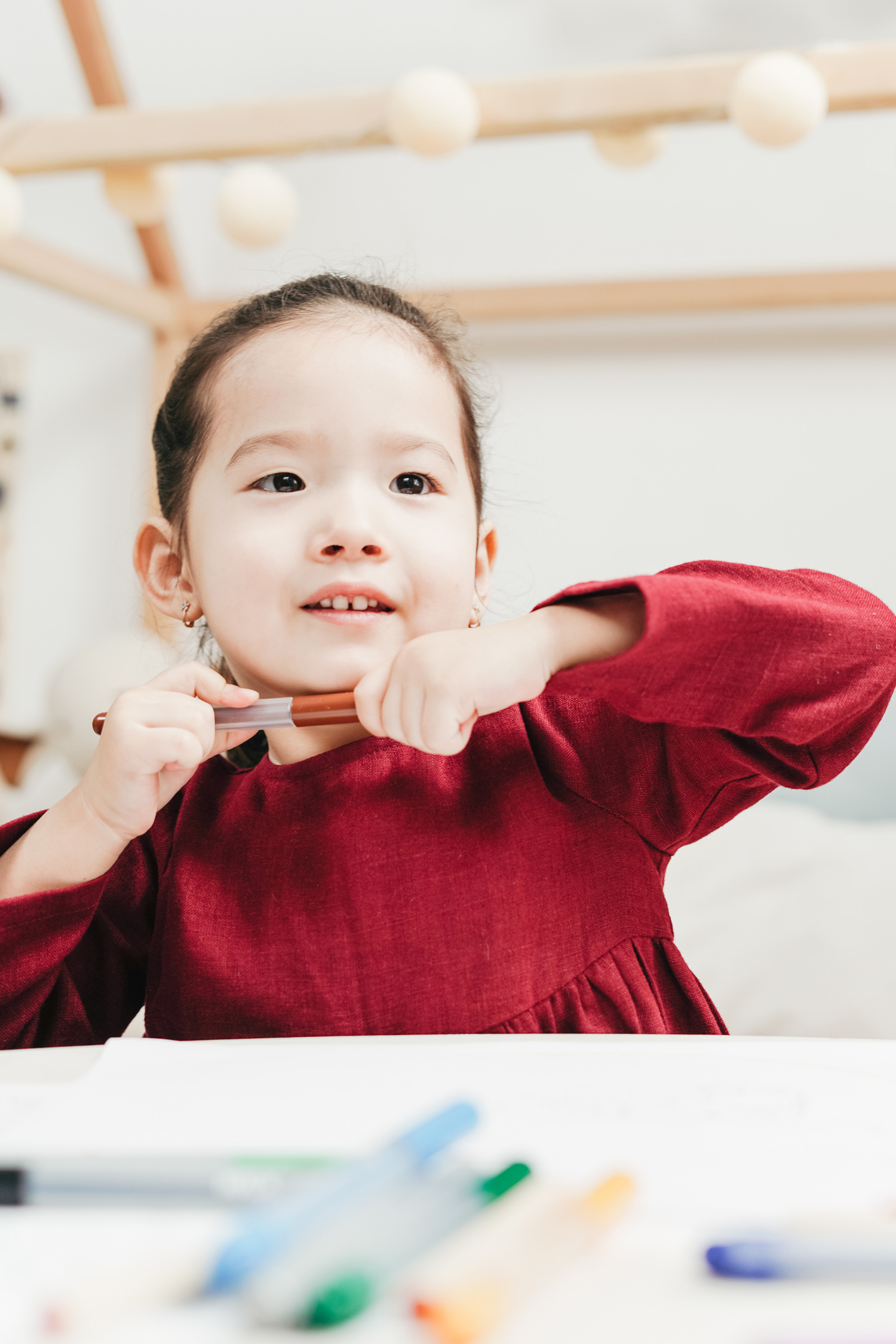 girl holding a paintbrush at a table