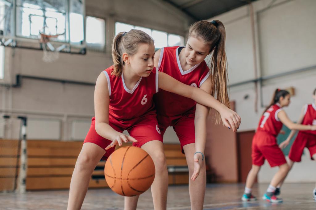 uniformed girls playing basketball in a gym