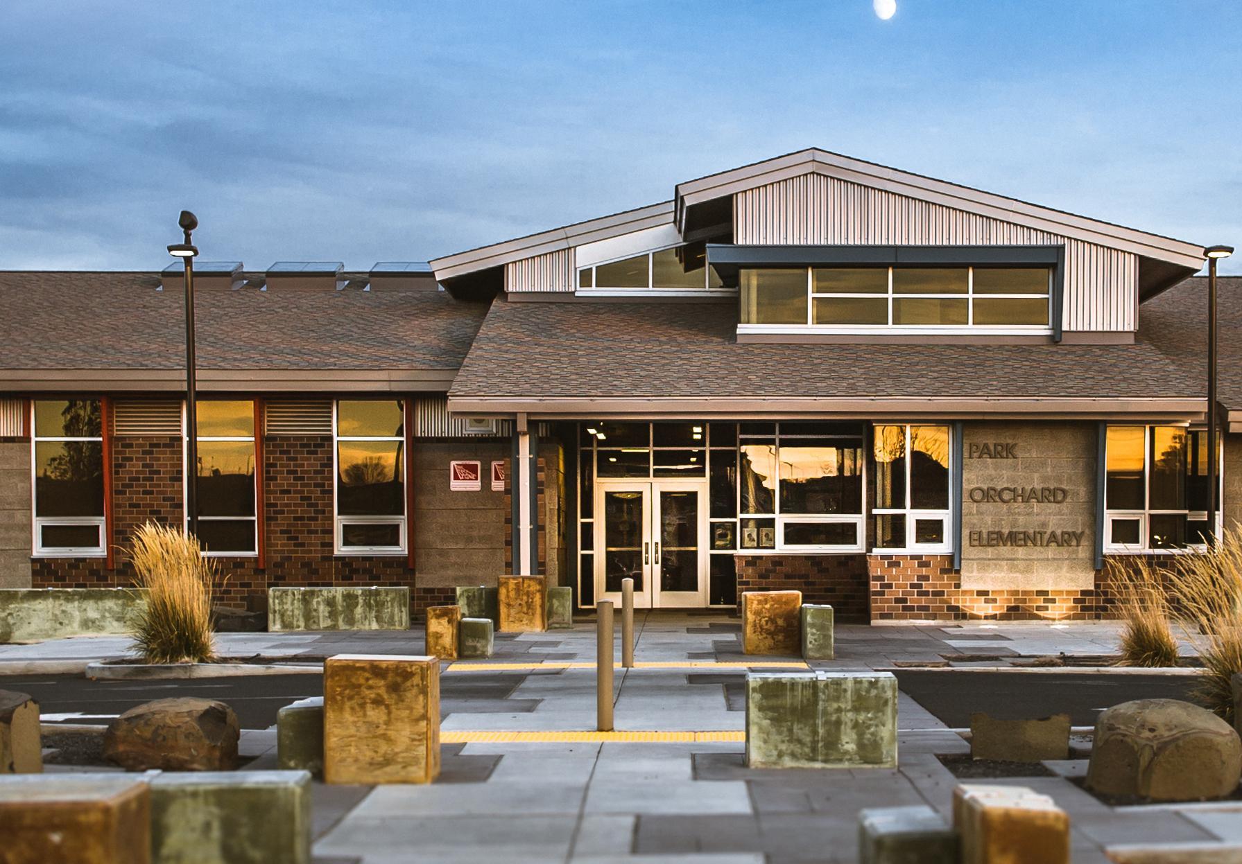 Front entrance to Park Orchard Elementary. Mostly clear sky with moon above school.