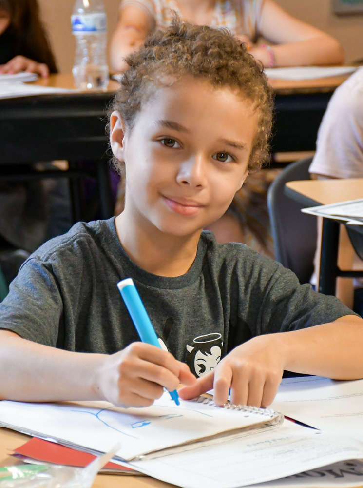 Boy sitting and working with marker and paper 