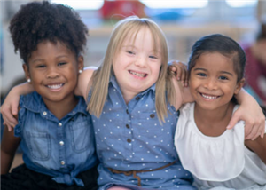 three students smiling with arms around each other