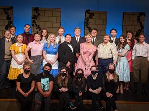 Cast and crew line up for a portrait onstage at Nampa High.