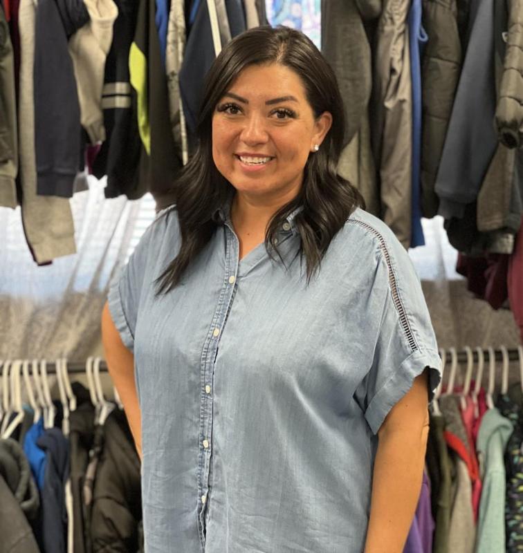 Elia Lopez in front of a rack of coats