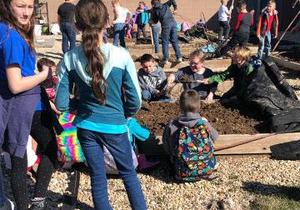 Children work to prepare the garden beds.